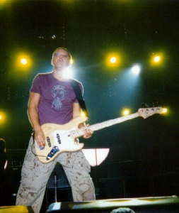 Photo of Adam Clayton on stage in the Dunkin Donuts Center, Providence RI, 31st October 2001