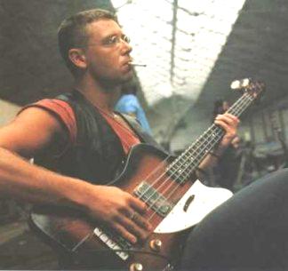 Adam Clayton plays the bass guitar